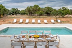 a table with plates of food next to a swimming pool at Villa My Love Mallorca in Bunyola
