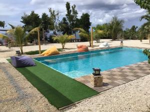 a swimming pool with a green lawn around it at Casa Ysatis in San Juan +8 photos