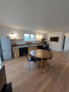 a room with a table and a kitchen with a refrigerator at Maisonnette individuelle in Figarol