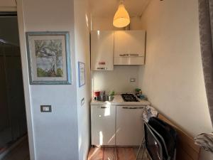 a small kitchen with a stove and a white refrigerator at Il Filo di Arianna 2 in Polverara +10 photos