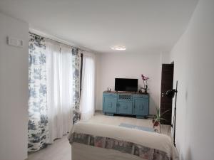 a bedroom with a bed and a tv in a room at A Casa di Laura in Parella