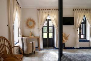 a living room with a door and a table and chairs at Bab Akoul Palmeraie - Boutique Hotel & Spa in Marrakesh