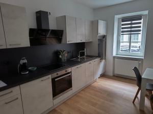 a kitchen with white cabinets and a black counter top at Ferienwohnung Löwenrevier in Winningen