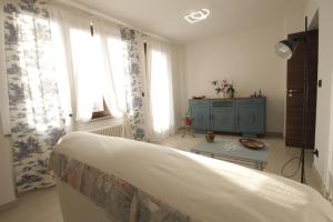 a bedroom with a bed and a room with windows at A Casa di Laura in Parella +18 photos