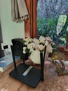 a vase of flowers sitting on a stand next to a window at Bubuhle Self Catering Cottage in Hogsback +10 photos