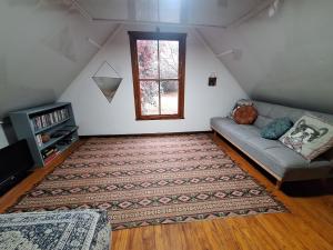 a living room with a couch and a window at Bubuhle Self Catering Cottage in Hogsback