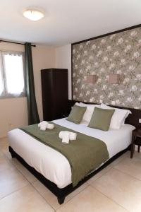 a bedroom with a large bed with two towels on it at Logis Hostellerie De L'Abbaye in Le Thoronet