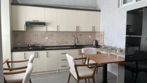 a kitchen with a wooden table and white cabinets at Bahrom Boutique Hotel in Khiva +25 photos