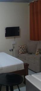 a living room with a couch and a flat screen tv at Dee Holiday Homes Studio-Bamburi Total in Mombasa