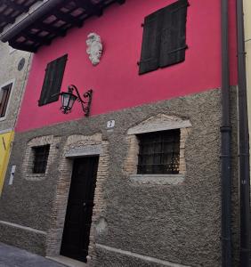 a pink building with windows and a door at Casa APOLLO in Palmanova