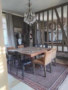 a dining room with a wooden table and chairs at Laclos des champs in Vadencourt