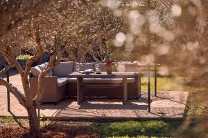 a table and a couch sitting under a tree at S'Hort de Son Caulelles - Adults Only in Marratxí 