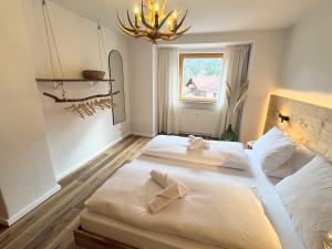 two beds in a room with a chandelier at Chic Alpine Oasis in Oberammergau with Mountain View in Oberammergau