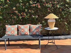 a lamp on a table next to a bench with pillows at Casa Junto a la Playa in El Rompido