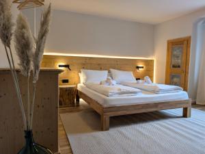 a bedroom with a bed with white sheets and pillows at Chic Alpine Oasis in Oberammergau with Mountain View in Oberammergau +21 photos