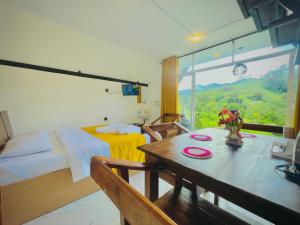 ein Schlafzimmer mit einem Bett und einem Tisch mit Blumen darauf in der Unterkunft Loop Side Cabin in Ella