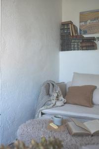 a living room with a couch and a table with books at Way's Cottage in McLaren Vale
