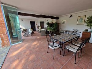 a patio with a table and chairs in a room at Guest House La Carolina in Tigliole