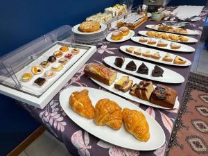 a table topped with plates of pastries and desserts at Albergo Residenza Al Teatro in Udine