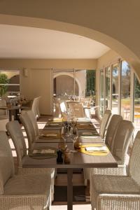 a dining room with a long table and chairs at Logis Hostellerie De L'Abbaye in Le Thoronet