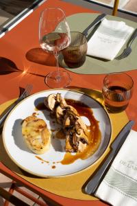a plate of food on a table with a wine glass at Logis Hostellerie De L'Abbaye in Le Thoronet +68 photos