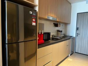a kitchen with a stainless steel refrigerator at Roxy Beach Apartment, Sematan, Sarawak in Sematan