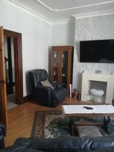a living room with a black leather chair and a table at The Bishop Bolthole in Bishop Auckland