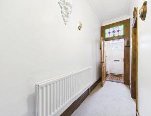 a hallway with white walls and a door with a window at The Bishop Bolthole in Bishop Auckland