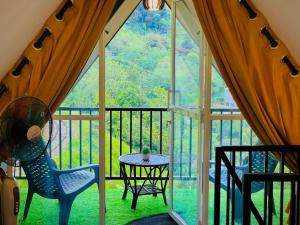 ein Zimmer mit Tisch und Stühlen auf einem Balkon in der Unterkunft Loop Side Cabin in Ella