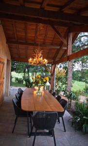 a dining room table with chairs and a chandelier at A Soulas in Armous-et-Cau