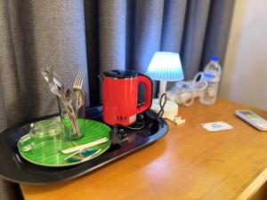 a tray with a red coffee cup on a desk at Home Stay Residence - Near Airport in Negombo