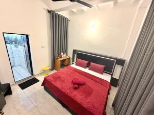 a bedroom with a large bed with a red blanket at Home Stay Residence - Near Airport in Negombo