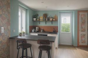 a kitchen with a counter and two bar stools at chambre vue Chartreuse in Pontcharra