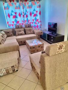 a living room with two couches and a tv at Sea Bliss Villa1 in Pereybere