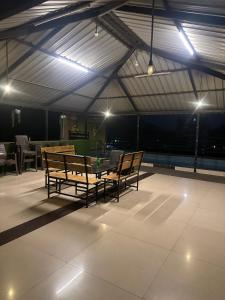 a room with two benches and a table on a roof at Vedanta Retreat in Igatpuri