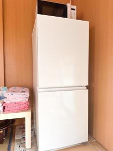 a white refrigerator with a microwave on top of it at 民泊Toshi29 in Wadomari +8 photos