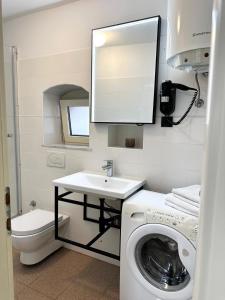 a bathroom with a washing machine and a sink at Apartment Kokolo in Šibenik +22 photos