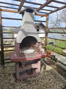 a outdoor brick oven with a wooden roof at Apartma Ob jezeru in Gradišče v Slovenskih Goricah