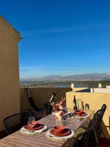 a table with plates and wine glasses on a balcony at Casa Jema - Family house with ocean views in Gran Alacant