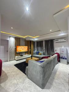 a living room with a couch and a television at The Adun Grove in Lekki