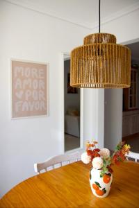 a dining room table with a vase with flowers on it at Casa Jema - Family house with ocean views in Gran Alacant