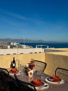 a table with a bottle of wine and glasses on it at Casa Jema - Family house with ocean views in Gran Alacant