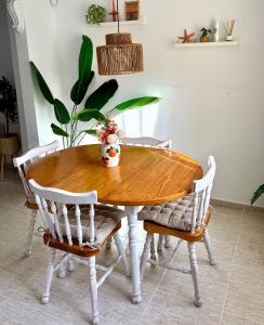 a wooden table with chairs and a vase on it at Casa Jema - Family house with ocean views in Gran Alacant +30 photos