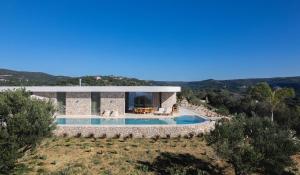 a villa with a swimming pool on a hill at Villa On the Rocks in Finikounta