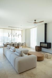 a living room with a white couch and a table at Villa On the Rocks in Finikounta