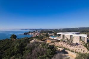 a house on a hill with a view of the ocean at Villa On the Rocks in Finikounta
