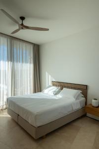 a bedroom with a bed and a ceiling fan at Villa On the Rocks in Finikounta +43 photos