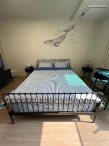 a bed in a room with a poster on the wall at Gwangalli #Modern #Korea in Busan