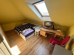 a bedroom with a bed and a desk with a computer at Apartmán Víťazov in Trenčín