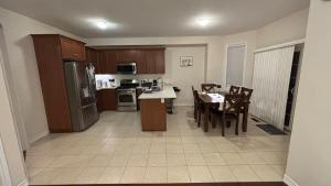 a kitchen with a table and chairs and a refrigerator at Halton Hills Haven in Milton